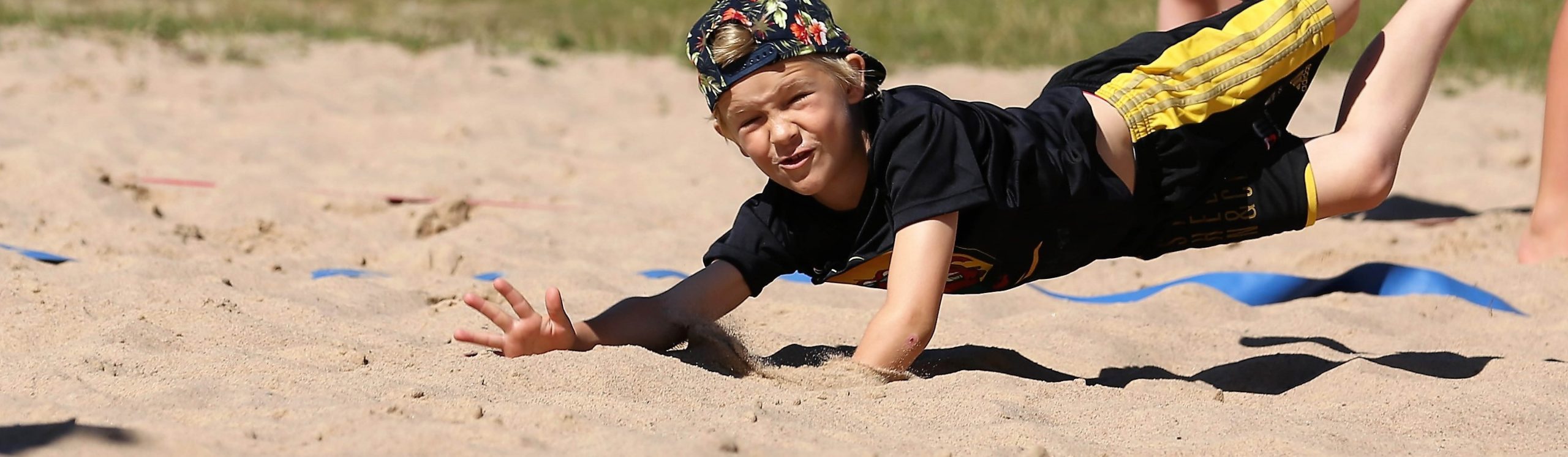 Pojke som spelar beachvolleyboll